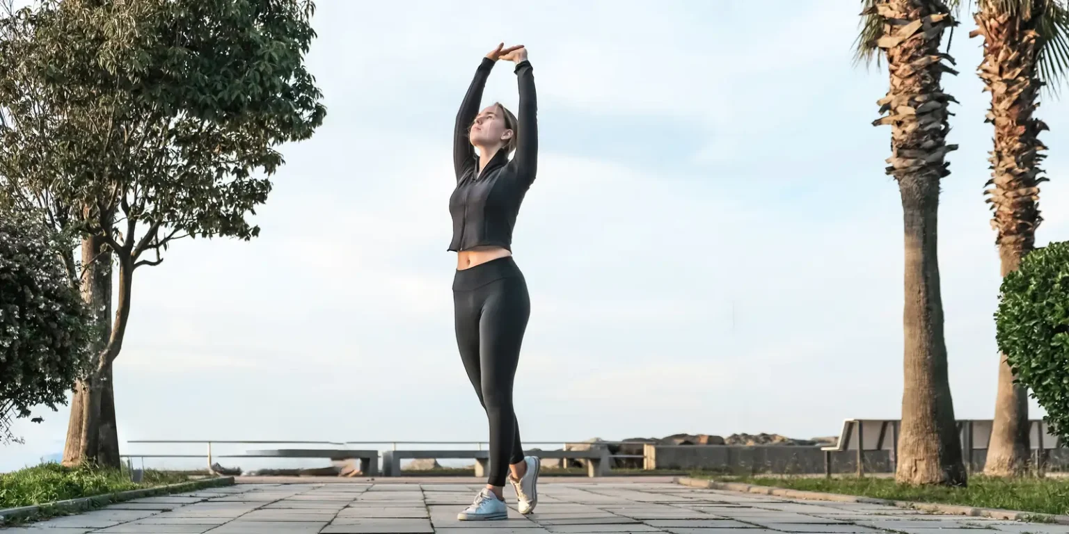 Persona haciendo ejercicios de calentamiento al aire libre